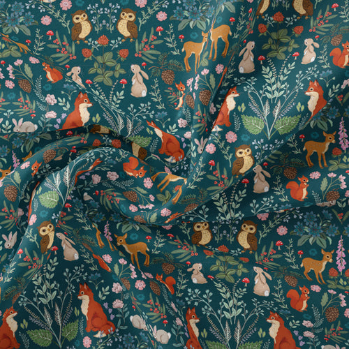 midnight forest fabric in a teal colourway. shows woodland animals like foxes, owls and bunnies amongst foliage