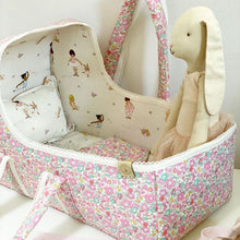 Load image into Gallery viewer, lifestyle image of a hand sewn  dolls bassinet lined with belle and boo&#39;s ballet fabric and a floral liberty print.  
