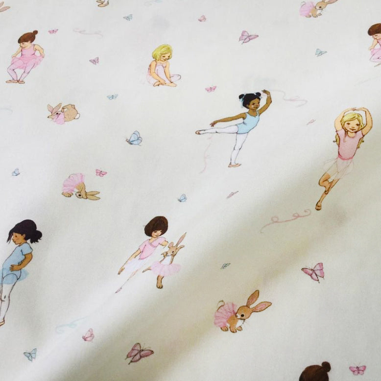 close up detail of belle and boo's ballet fabric featuring illustrations of ballerinas dancing with butterflies. 