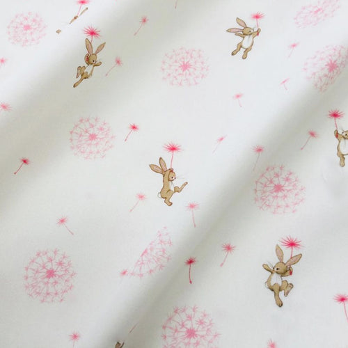 photo of fabric with white background and pink dandelion puffs with boo the bunny flying on dandelion clocks. 