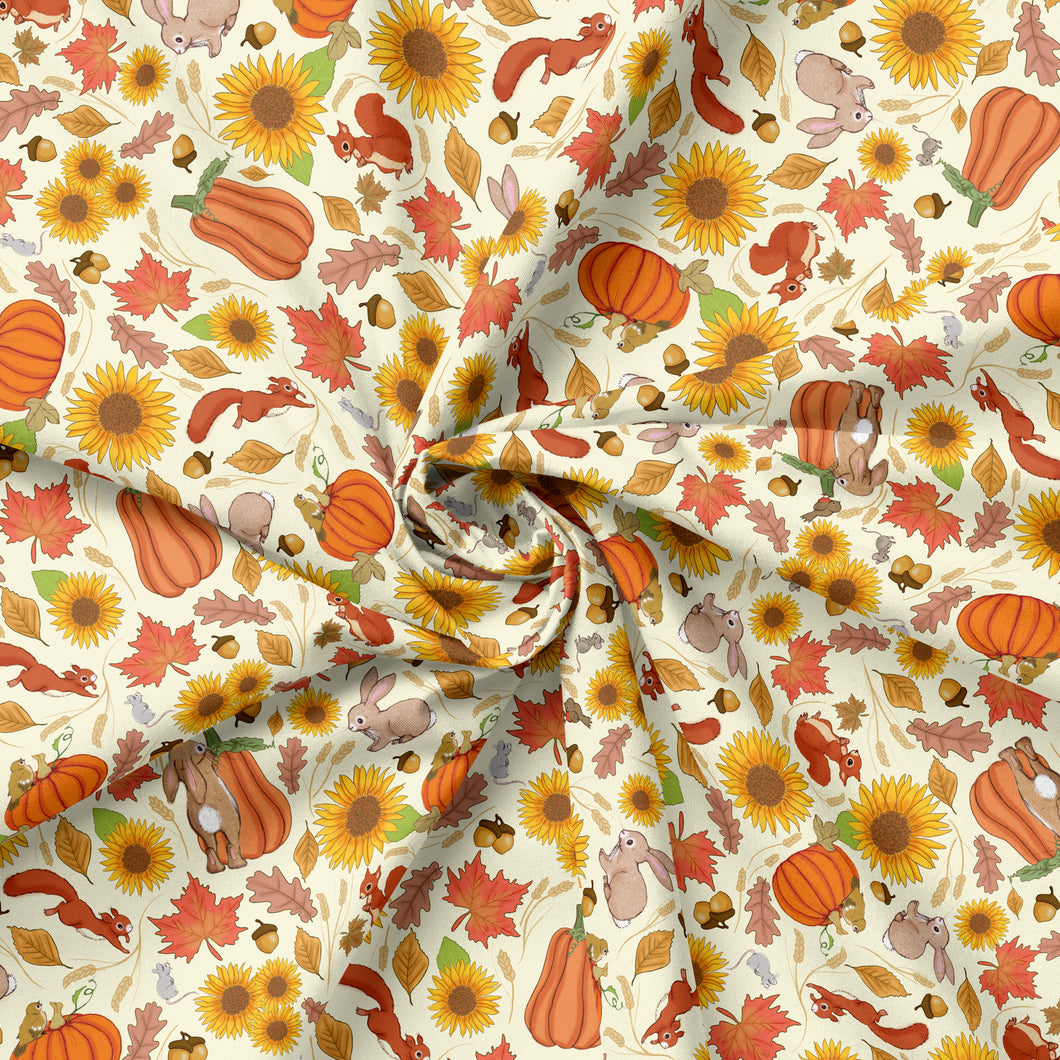 Autumn fabric featuring orange and yellow pumpkins and sunflowers. There are also squirrels, bunnies, and birds